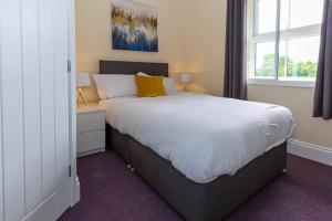 Bramall House Accommodation في Fewston: غرفة نوم بسرير كبير ونافذة