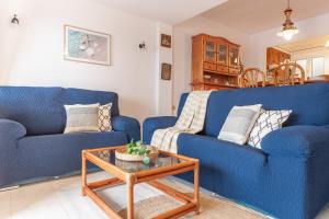 萊斯卡拉的住宿－Apartamento El Capitan，客厅配有2张蓝色的沙发和1张桌子