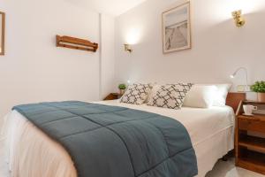 Un dormitorio con una cama con una manta azul. en Apartamento El Capitan en L'Escala