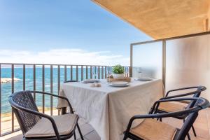 een tafel en stoelen op een balkon met uitzicht op de oceaan bij Apartamento El Capitan in L'Escala
