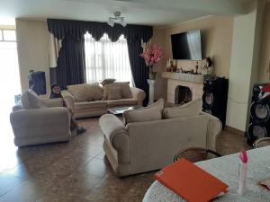 a woman sitting on a couch in a living room at CASA CAMPESTRE SANTERRA in Tacna