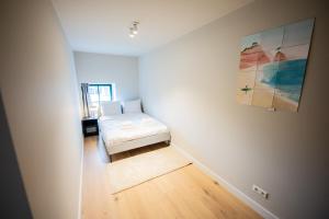 Habitación con cama y pintura en la pared en Deluxe 3 Bedroom Serviced Apartment 73m2, en Róterdam