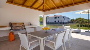 cocina y comedor con mesa y sillas en Villa Palma en Malinska