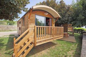 een houten hut met een poort en een veranda bij CityKamp Valkenburg - Maastricht in Valkenburg