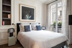 a bedroom with a large bed with blue and white pillows at The very central location allows you to go everywhere in Paris in 30 minutes in Paris