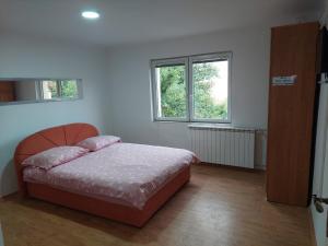a bedroom with a bed and two windows at Hostel Bobito in Sarajevo