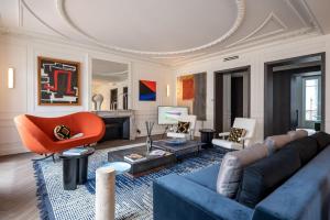 a living room with a blue couch and orange chair at The very central location allows you to go everywhere in Paris in 30 minutes in Paris
