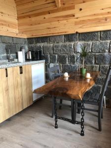 a wooden table in a kitchen with a stone wall at Şeni Bungalow in Çamlıhemşin