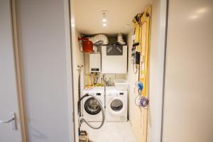 a laundry room with a washer and a washing machine at Exquisite 3 Bedroom Apartment in Rotterdam
