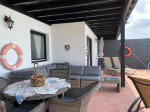 een patio met een bank en een tafel en stoelen bij Villa Burgao in Playa Blanca