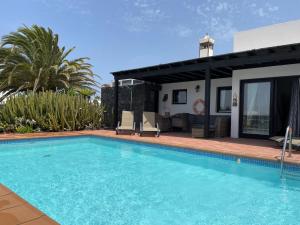a swimming pool in front of a house at Villa Burgao in Playa Blanca
