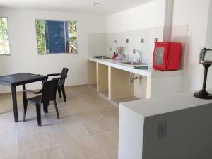 a kitchen with a table and a red microwave at GiGi House Taganga in Taganga