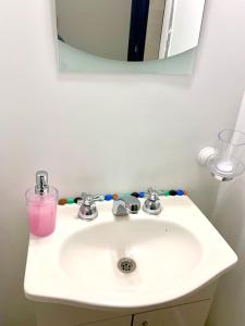 lavabo con espejo y taza rosa en Alto Nqn en Neuquén