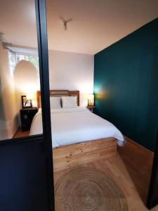 um quarto com uma cama e uma parede azul em Nid douillet à quelques pas de la gare. em Carcassonne
