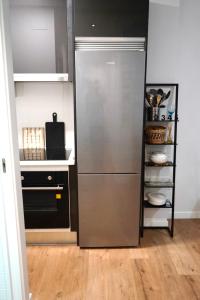a kitchen with a stainless steel refrigerator and a shelf at Casa Galdós in Logroño