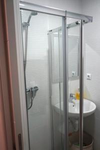 a bathroom with a glass shower and a sink at Casa Galdós in Logroño