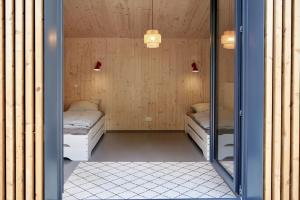 a room with two beds and a mirror at Elf am See - Haus 7 in Templin