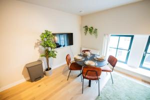a dining room with a table and chairs and a tv at Flawless 3 Bedroom Apartment in Rotterdam