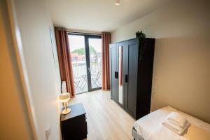 a bedroom with a bed and a door to a balcony at Flawless 3 Bedroom Apartment in Rotterdam