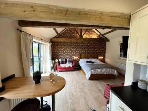 a bedroom with a bed and a table in a room at Peak District Old Forge In Over Haddon in Bakewell