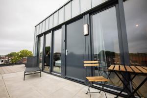 un balcone con porte in vetro e sedie su un edificio di Adorned 3 Bedroom Apartment a Rotterdam