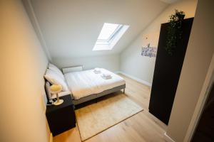 una piccola camera mansardata con letto e finestra di Adorned 3 Bedroom Apartment a Rotterdam