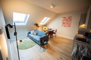 a living room with a blue couch and a table at Beloved 3 Bedroom Apartment in Rotterdam