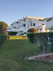 a large white apartment building with a green yard at Albufeira - Casa Balaia Resort in Albufeira +34 photos