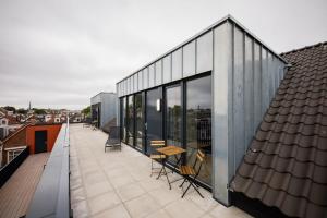 a house on a roof with a table on a balcony at Beloved 3 Bedroom Apartment in Rotterdam