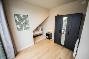 una habitación con una puerta negra y una silla en Beloved 3 Bedroom Apartment, en Róterdam