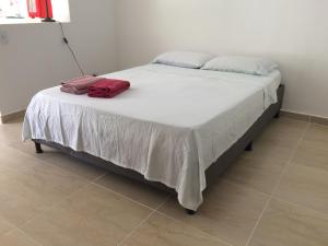 un letto con un asciugamano rosso sopra di GiGi House Taganga a Taganga