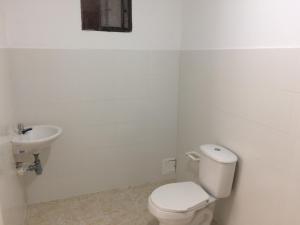 een witte badkamer met een toilet en een wastafel bij GiGi House Taganga in Taganga