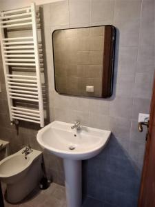 La salle de bains est pourvue d'un lavabo, d'un miroir et de toilettes. dans l'établissement SISU BUSSI SUITE, à Bussi sul Tirino