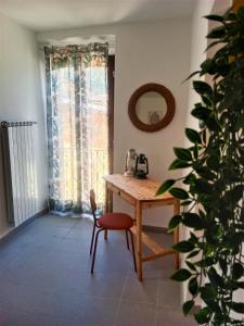 Habitación con mesa, silla y espejo. en SISU BUSSI SUITE en Bussi sul Tirino