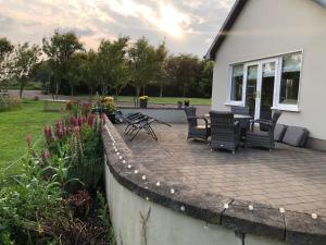 a patio with chairs and a table in front of a house at Boutique En-Suite Bedroom Cork in Mallow