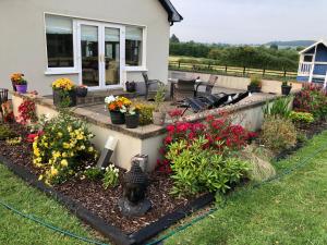 a garden in front of a house with flowers at Boutique En-Suite Bedroom Cork in Mallow