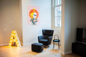 un salon avec une chaise et un tableau mural dans l'établissement Ample 3 Bedroom Apartment, à Rotterdam