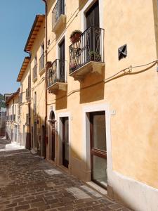 a building with two balconies on a street at SISU BUSSI SUITE in Bussi sul Tirino