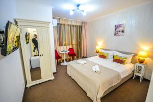 a hotel room with a large bed and a mirror at Boutique House Deva in Deva