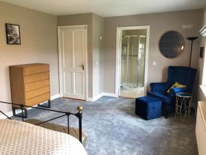 1 dormitorio con 1 cama y 1 silla azul en Boutique En-Suite Bedroom Cork, en Mallow