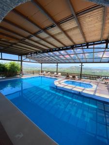 a large swimming pool with a view of the mountains at Hotel Shpija e Gjyshit in Shkodër