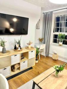 sala de estar con mesa y TV en la pared en JB Stays Greenwich Central, en Londres