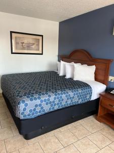 a bedroom with a bed with a blue wall at Budget Inn in Roswell