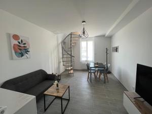 ein Wohnzimmer mit einem Sofa und einem Tisch in der Unterkunft 180B - Duplex T2 Tout Confort - Wifi Netflix in Le Gond-Pontouvre