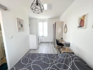 Habitación blanca con cama y escritorio. en 180B - Duplex T2 Tout Confort - Wifi Netflix, en Le Gond-Pontouvre