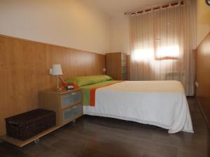 sypialnia z dużym łóżkiem i komodą z lampką w obiekcie La Llar de Peramola w mieście Peramola