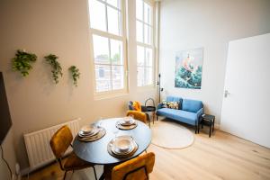 een woonkamer met een tafel en een blauwe bank bij Breathtaking 3 Bedroom Apartment in Rotterdam