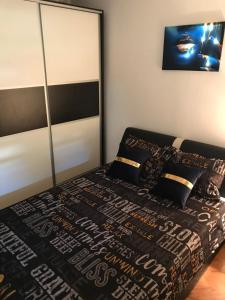 - une chambre avec un lit et une couette noire et blanche dans l'établissement Apartman/Stan na dan Teslić, à Teslić