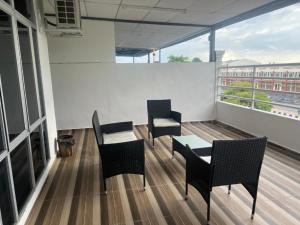 a room with chairs and a table on a balcony at Laena Homestay in Kangar
