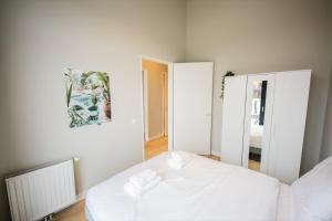 een slaapkamer met een wit bed en een spiegel bij Breathtaking 3 Bedroom Apartment in Rotterdam